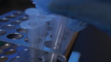 Metal raftan boş şırıngalar çıkartılıyor. Kapat, Kapalı