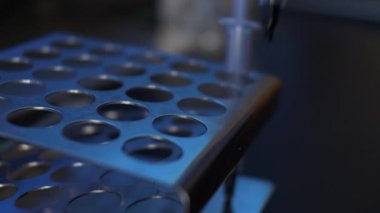 Boş şırıngalar metal bir rafa yerleştiriliyor. Kapat, Kapalı