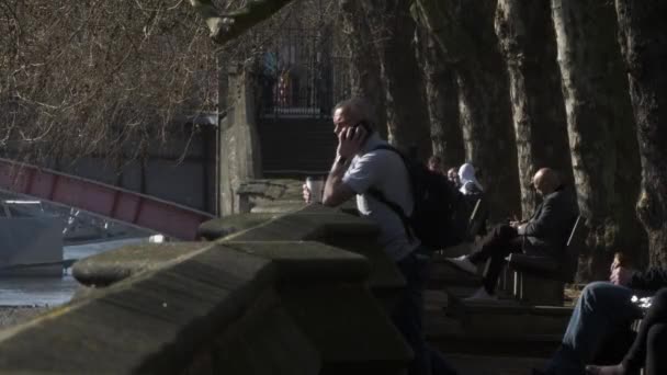 Vuxen Man Använder Mobiltelefon Vid Riverfront Bredvid Bänkar Westminster Låst — Stockvideo