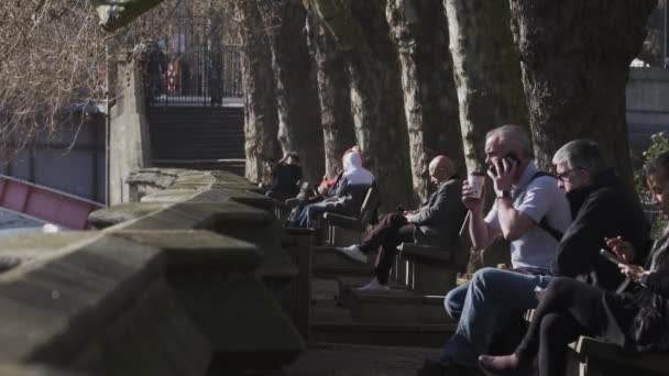 People Riverfront Benches Enjoying Sun Westminster Inglés Cerrado — Vídeo de stock