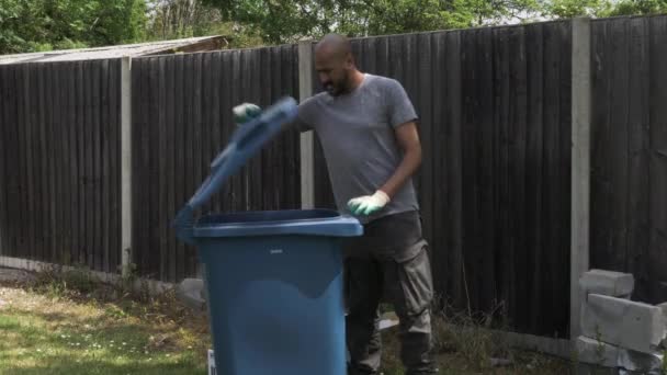 Volwassen Britse Aziatische Man Sorteren Karton Naast Blauwe Recycling Bin — Stockvideo