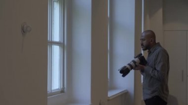 Yetişkin İngiliz Asyalı Kel Erkek Ofis Penceresinden Gözetleme Fotoğrafları Çekiyor. Kilitli