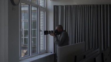 Pencereden fotoğraf çekmek için özel dedektif telefoto lenslerini kullanıyor. Kilitli
