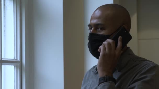 Britischer Asiatischer Mann Spricht Durch Gesichtsmaske Neben Bürofenster Abgeriegelt — Stockvideo
