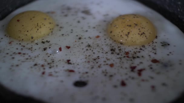 Chilli Flakes Being Prinkled Two Fried Egg Pan 타임스 폐쇄되어 — 비디오