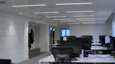 Londra 'daki açık planlı ofis binasında boş masalar ve sandalyeler. Yavaşça Uzaklaş