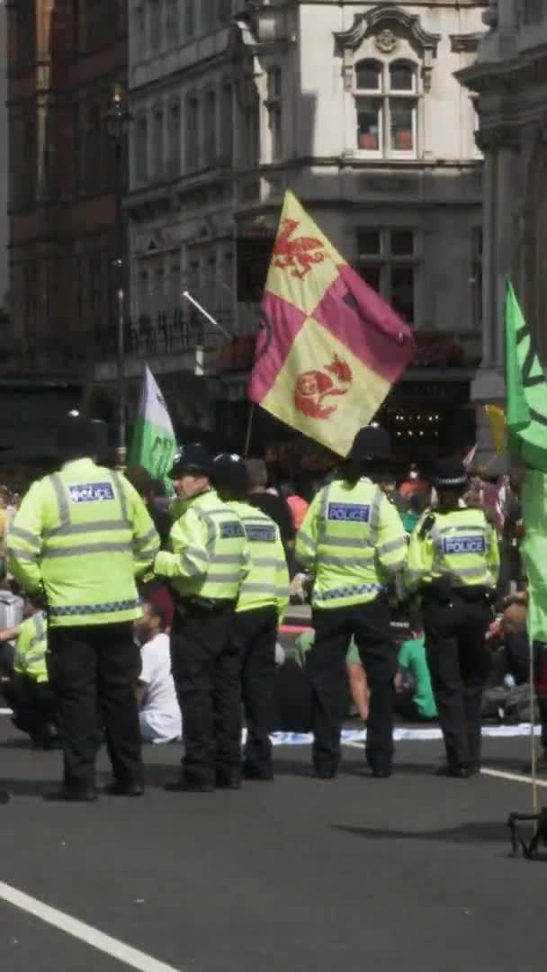 ロンドンの気候変動抗議行動のロンドン警察官 垂直ビデオ ロックオフ — ストック動画