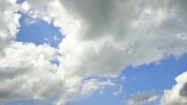Passing and swirling fast clouds in a blue sky