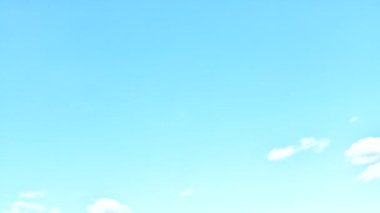 Passing and swirling fast clouds in a blue sky