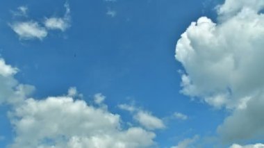 Passing and swirling fast clouds in a blue sky