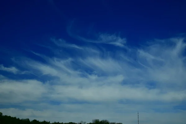 clouds over a field in a blue sky