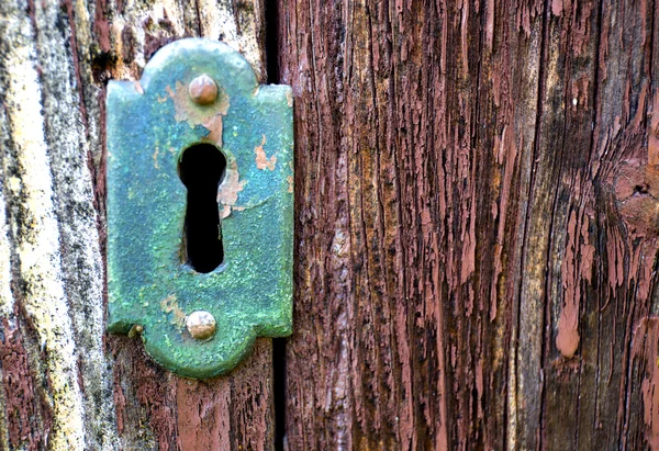 Primo piano di un vecchio buco della serratura con chiave su una porta in legno antico — Foto Stock