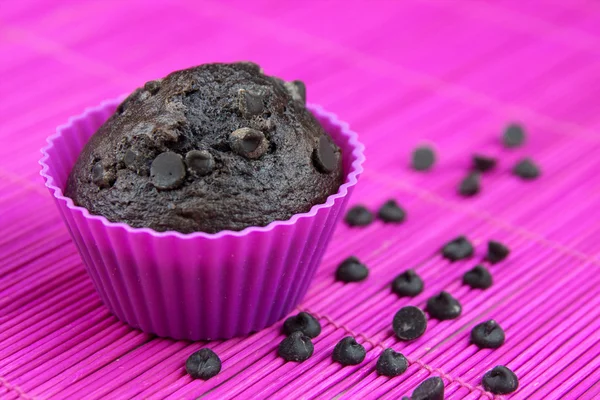 Cierre de muffins de chocolate en un mantel de madera y rosa — Foto de Stock