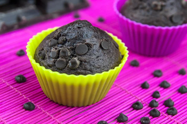 Primo piano di muffin al cioccolato su una tovaglietta di legno e rosa — Foto Stock