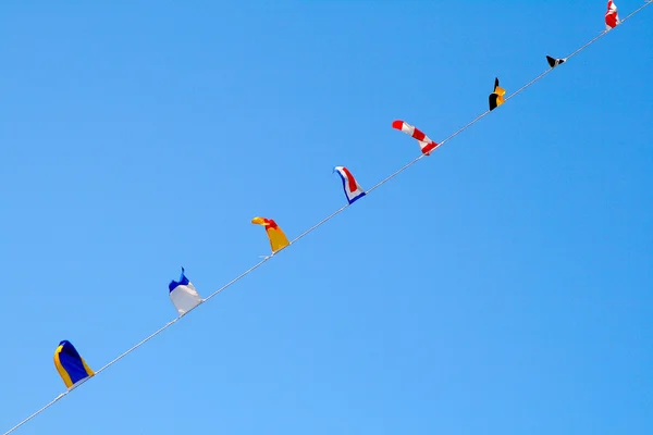 Bandeiras náuticas contra o céu azul — Fotografia de Stock