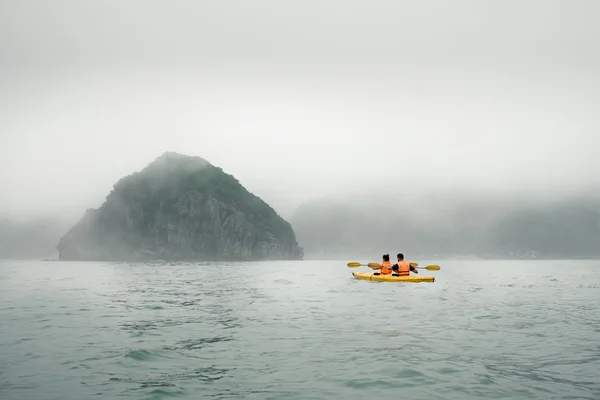 霧天候でカヤックを漕ぐカップル — ストック写真