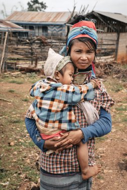 Padaung (Karen) evin yakınında çocuklu kadın, Myanmar