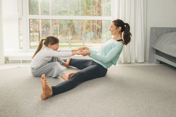 Giovane madre e figlia che fanno esercizio mattutino di yoga — Foto Stock