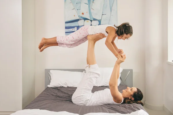 Μάνα με κόρη κάνει άσκηση γιόγκα στο κρεβάτι — Φωτογραφία Αρχείου