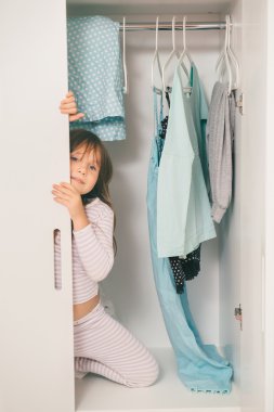 Sevimli küçük kız gardıropta saklanıyor