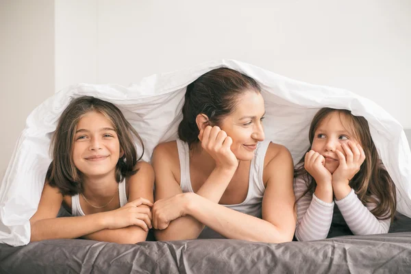 Mother having fun with children in the bed — Stock Photo, Image