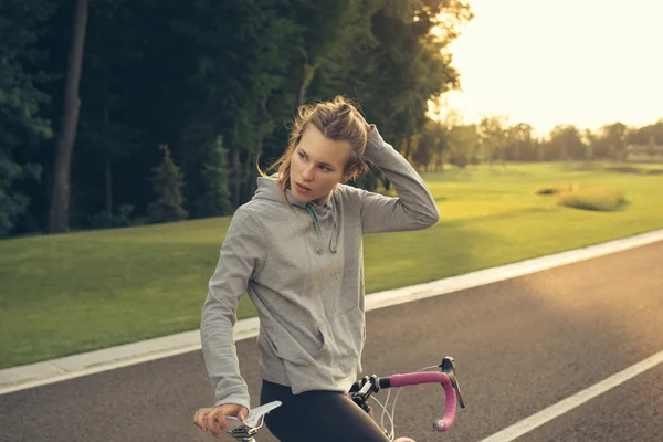 Active  woman with bicycle at sunset — Stock Photo, Image