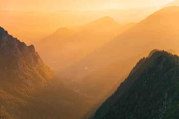 Goldener Sonnenuntergang mit Sonnenstrahlen in großer Berglandschaft — Stockfoto