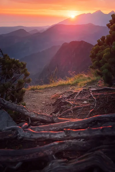 Goldener Sonnenuntergang mit Sonnenstrahlen in großer Berglandschaft Stockbild