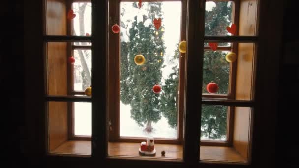 Зимний пейзаж с падающим снегом сквозь оконный силуэт — стоковое видео