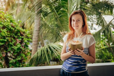 Genç turist kadın, Asya 'da hindistan cevizi içiyor. 