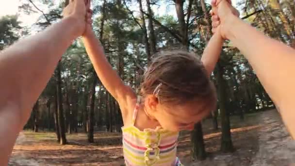 Heureux enfant tourner autour dans les mains du père dans la forêt au coucher du soleil — Video