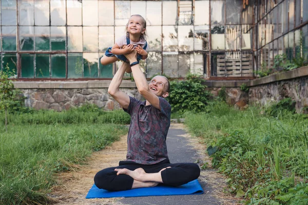 Far och dotter gör yoga tillsammans i parken — Stockfoto