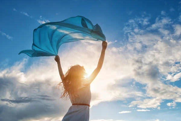 Bella giovane donna che tiene la sciarpa blu sul vento — Foto Stock