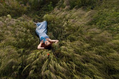 Uzun otların üzerinde uyuyan güzel kadın