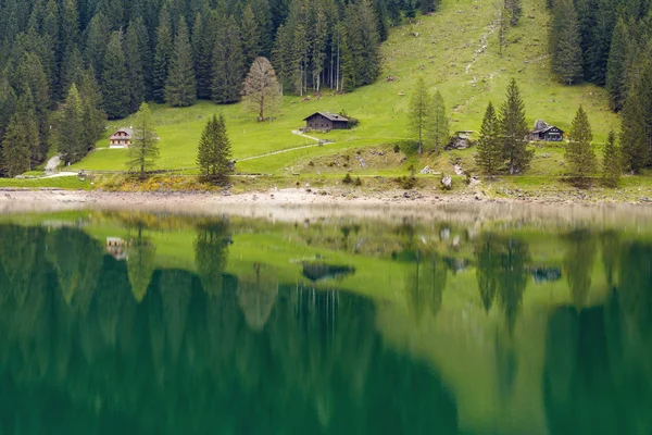 Casa de montanha alpina na floresta refletida na água — Fotografia de Stock