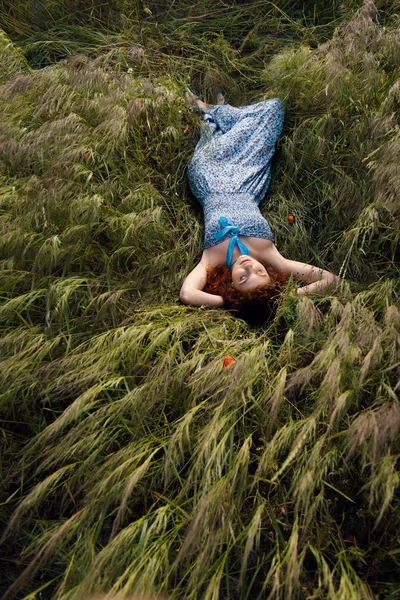 Красивая женщина спит на высокой траве — стоковое фото