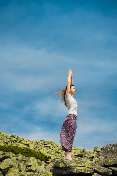 Mulher fazendo exercício de ioga no ar fresco com céu azul no backgrou — Fotografia de Stock