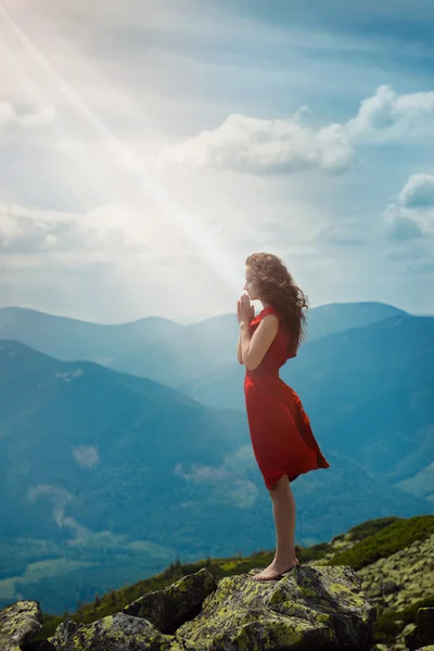 Beautiful woman praying in mountain landscape — Stock Photo, Image