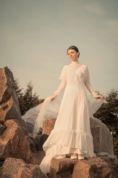 Mulher bonita segurando cachecol branco no fundo por do sol — Fotografia de Stock