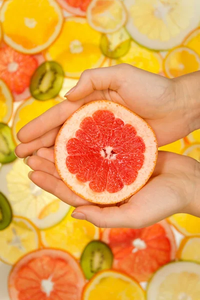 Fresh grapefruit slice in woman hands — Stock Photo, Image