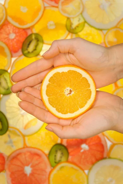 Fresh orange slice in woman hands — Stock Photo, Image