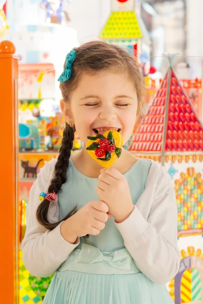 Happy girl licking candy — Stock Photo, Image