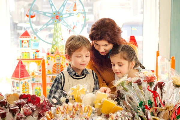 Mother with happy children in the candy store — Stock Photo, Image