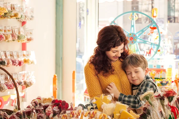 Happy boy with his mouter in a candy store — Stock Photo, Image