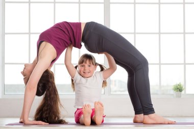 genç anne ve kızı yoga egzersiz yaparak