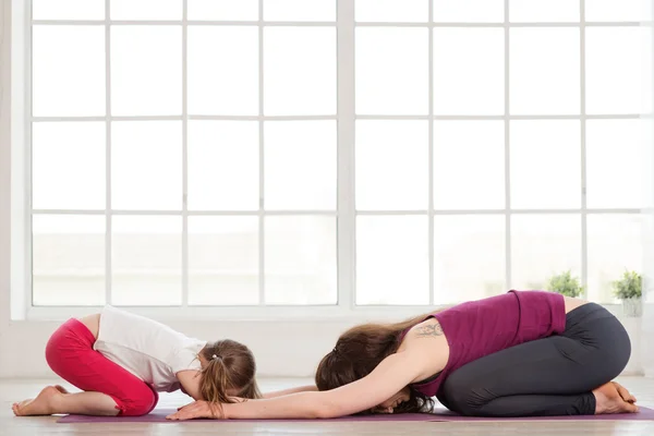 Jonge moeder en dochter doen yoga oefening — Stockfoto