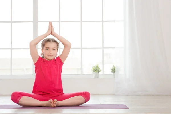 Petite fille souriante en position lotus — Photo