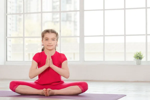 Petite fille souriante en position lotus — Photo