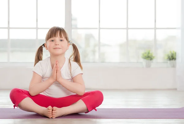 Petite fille souriante en position lotus — Photo