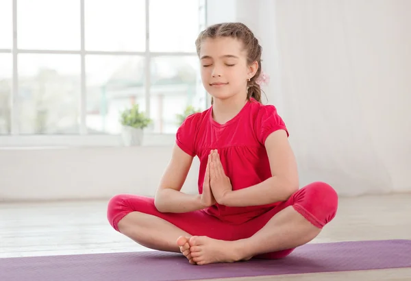 Petite fille assise en position lotus avec les yeux fermés — Photo